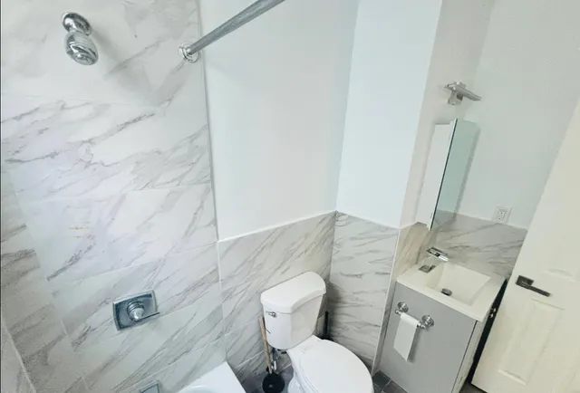 a white toilet sitting next to a bathroom sink