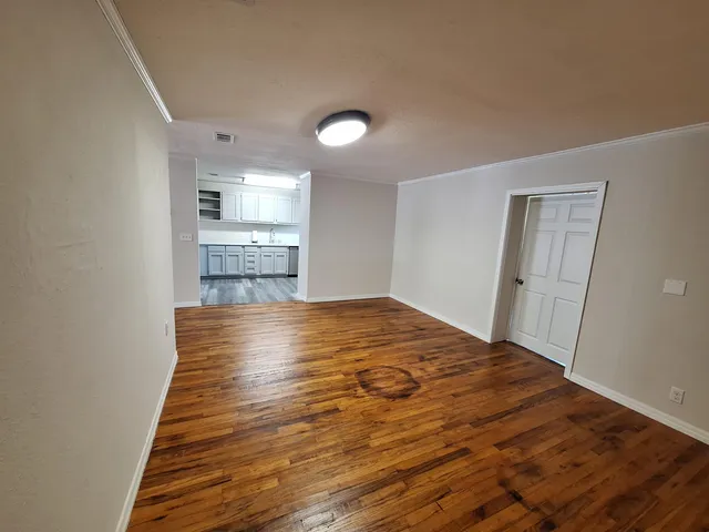 a view of empty room with wooden floor