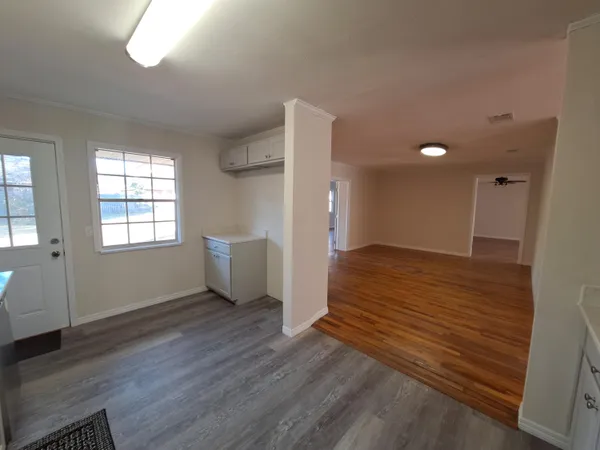 a view of empty room with wooden floor