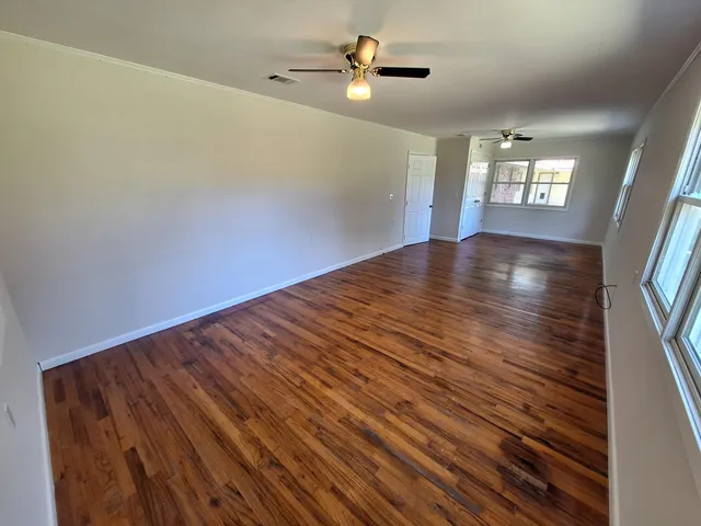 wooden floor in an empty room with a window