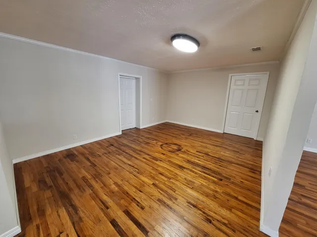 a view of empty room with wooden floor