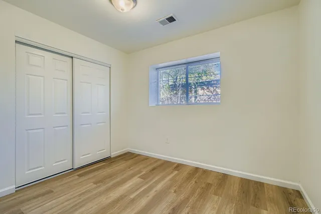 a view of an empty room with wooden floor