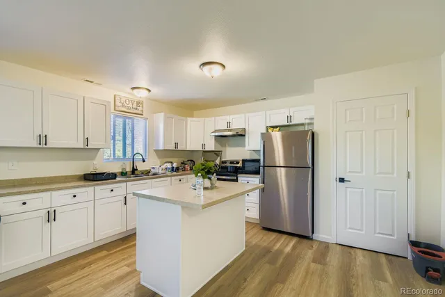 a view of a kitchen area with furniture and wooden floor