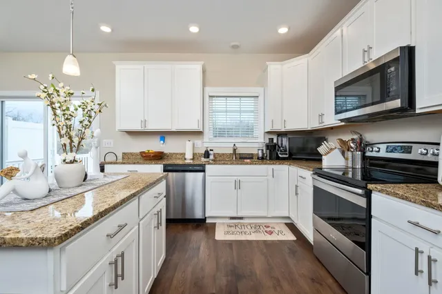 a kitchen with granite countertop white cabinets and white appliances