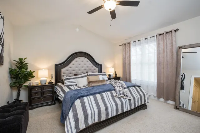 a bedroom with a bed couch and a window