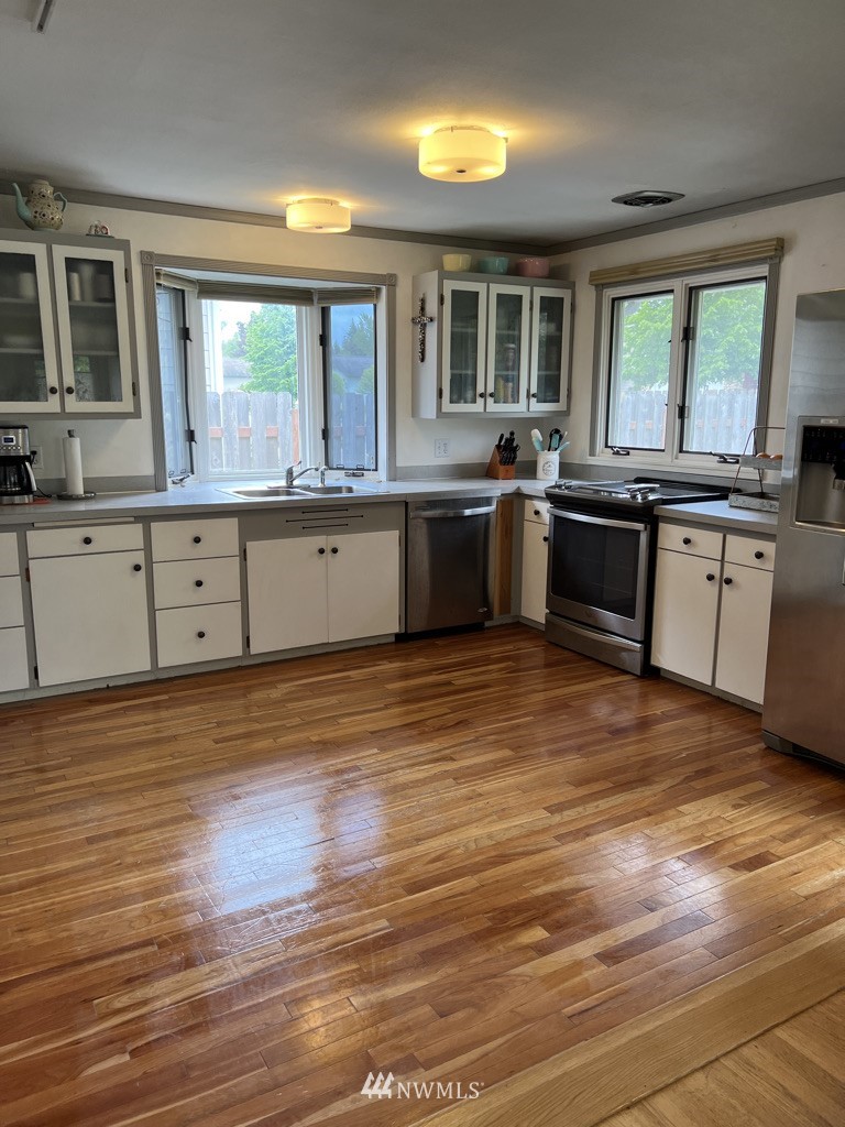 1375 West Smith Road Ferndale, WA 98248 - Photo 8 of 19 a kitchen with stainless steel appliances granite countertop a stove a sink wooden floors and a large window
