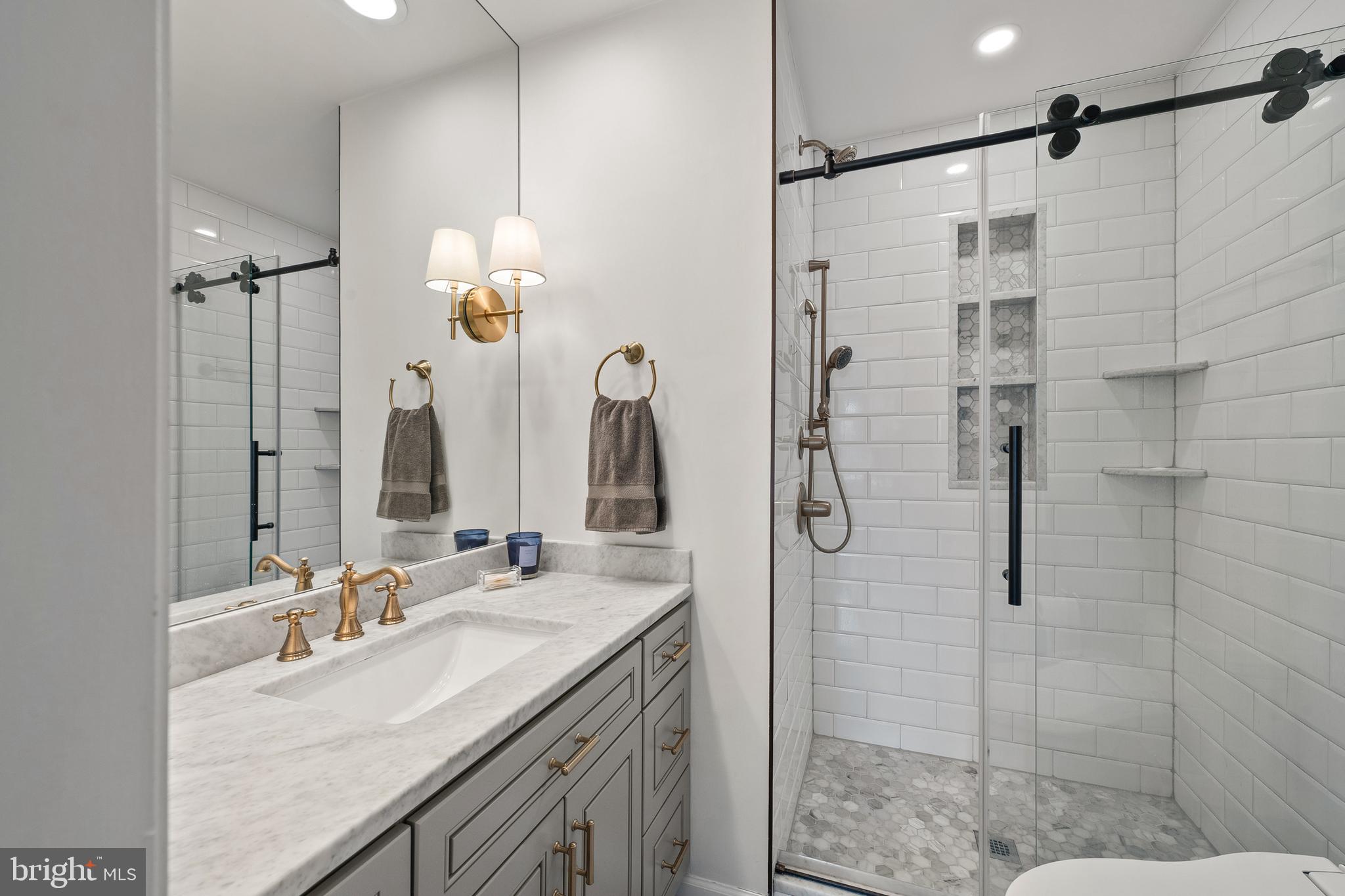 520 D Street Northeast Washington, DC 20002 - Photo 7 of 15 a bathroom with a granite countertop shower sink and mirror