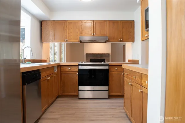 a kitchen with kitchen island granite countertop a stove a sink and a window