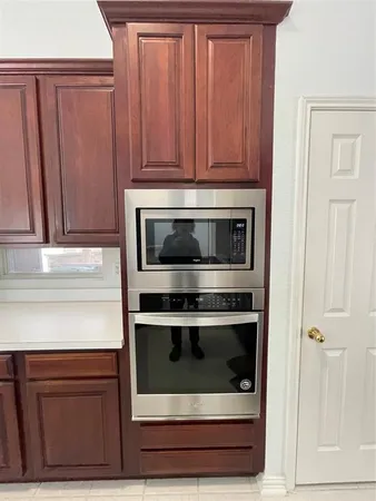 a kitchen with granite countertop wooden cabinets and oven