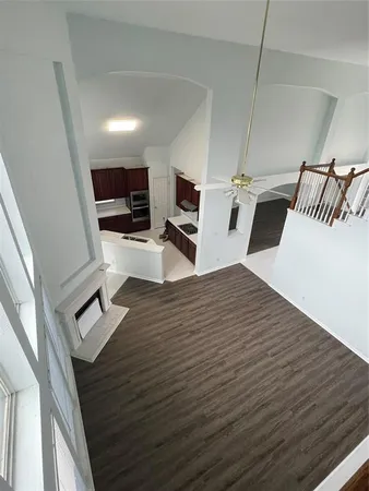 a hallway with a computer on a desk and wooden floor