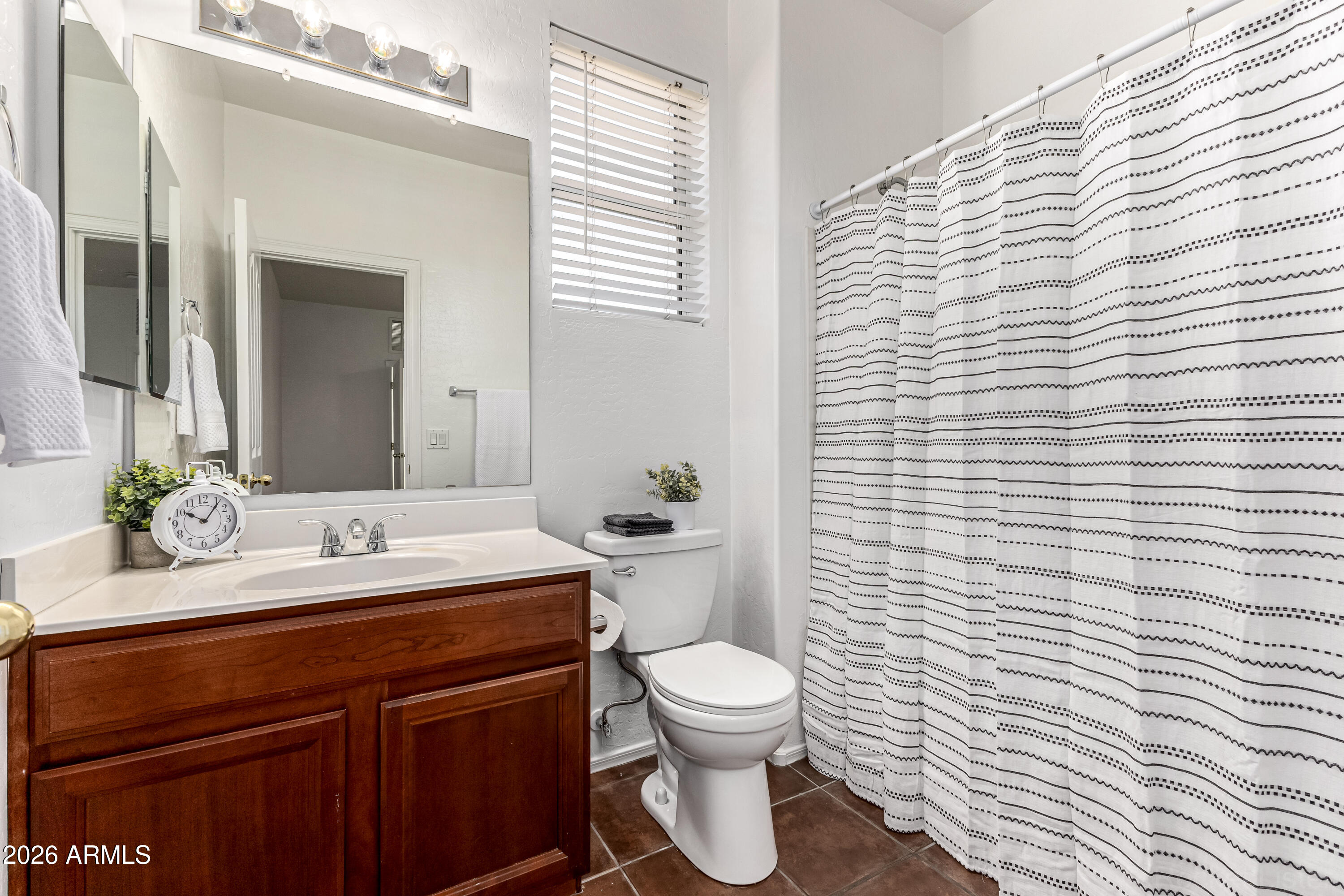 970 West Aspen Way Gilbert, AZ 85233 - Photo 22 of 36 a bathroom with a toilet a sink and a large mirror