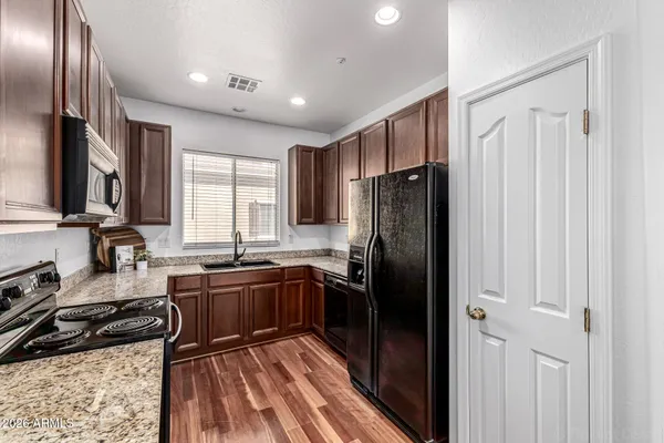 a kitchen with granite countertop stainless steel appliances a refrigerator sink and stove