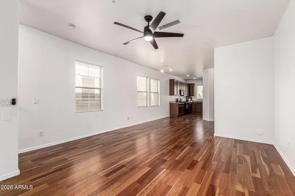 a view of empty room with wooden floor and ceiling fan