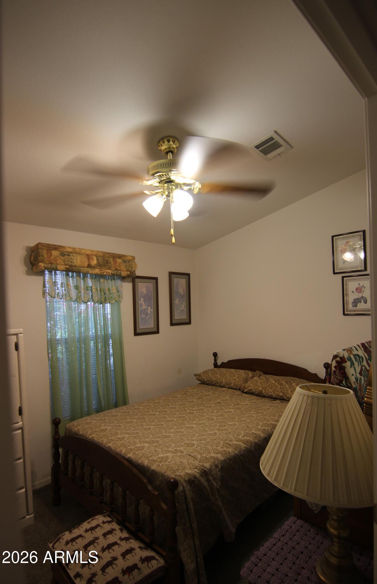201 South Greenfield Road, Unit 268 Mesa, AZ 85206 - Photo 11 of 22 a bedroom with a bed and a chandelier