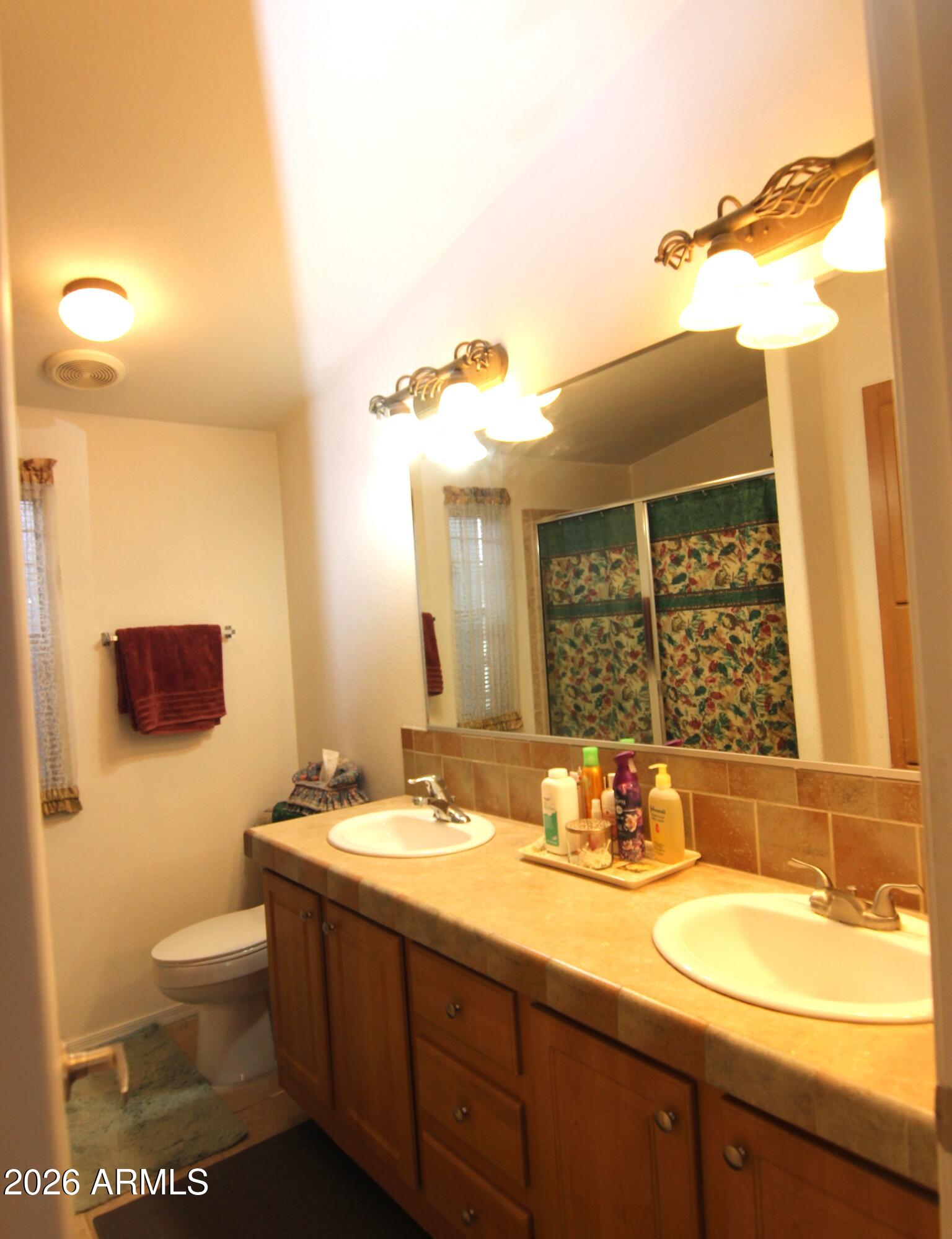 201 South Greenfield Road, Unit 268 Mesa, AZ 85206 - Photo 15 of 22 a bathroom with a granite countertop sink mirror and a toilet