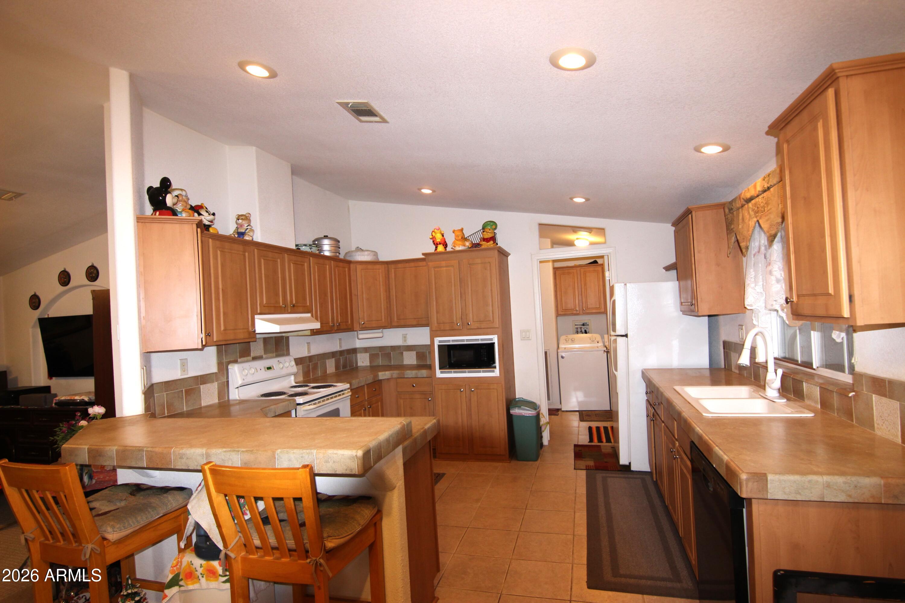 201 South Greenfield Road, Unit 268 Mesa, AZ 85206 - Photo 7 of 22 a kitchen with a table chairs refrigerator and a sink