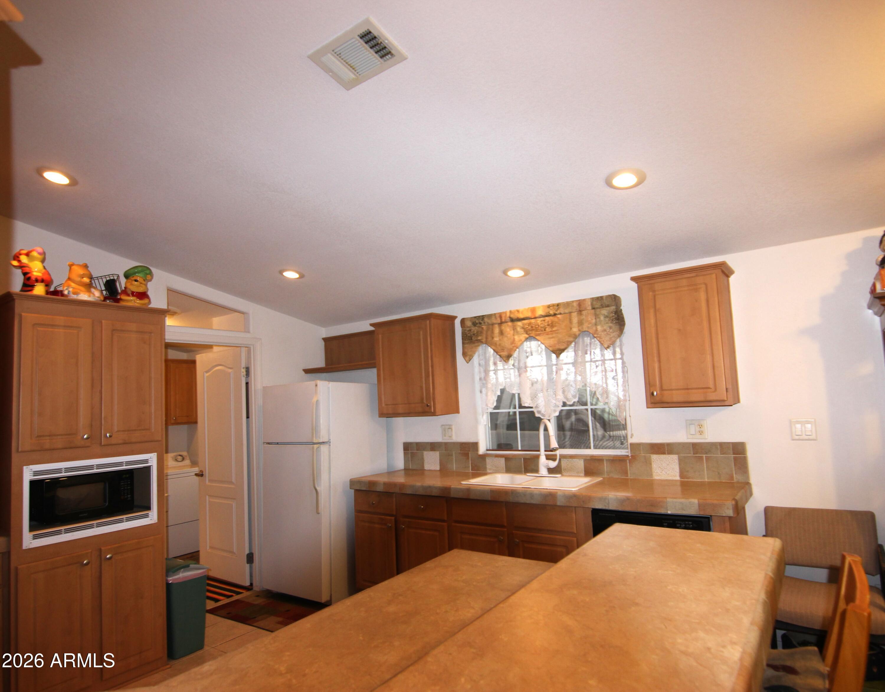 201 South Greenfield Road, Unit 268 Mesa, AZ 85206 - Photo 8 of 22 a kitchen with granite countertop a refrigerator stove and microwave
