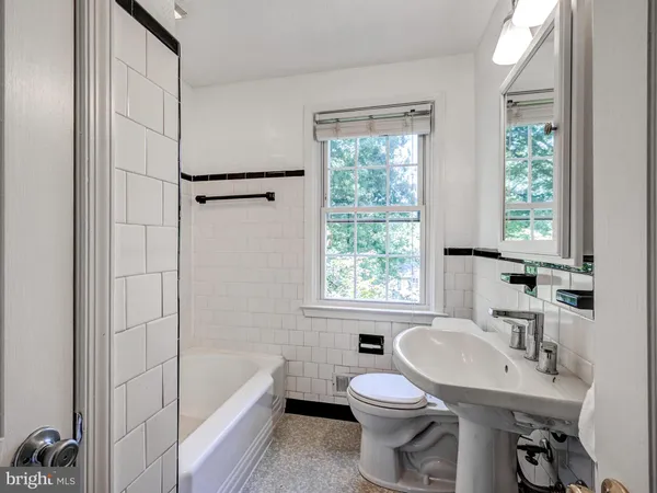 a bathroom with a sink toilet a mirror and tub