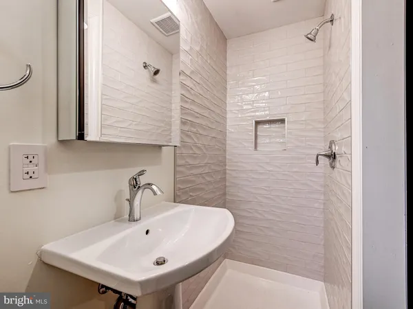 a bathroom with a sink a mirror and shower