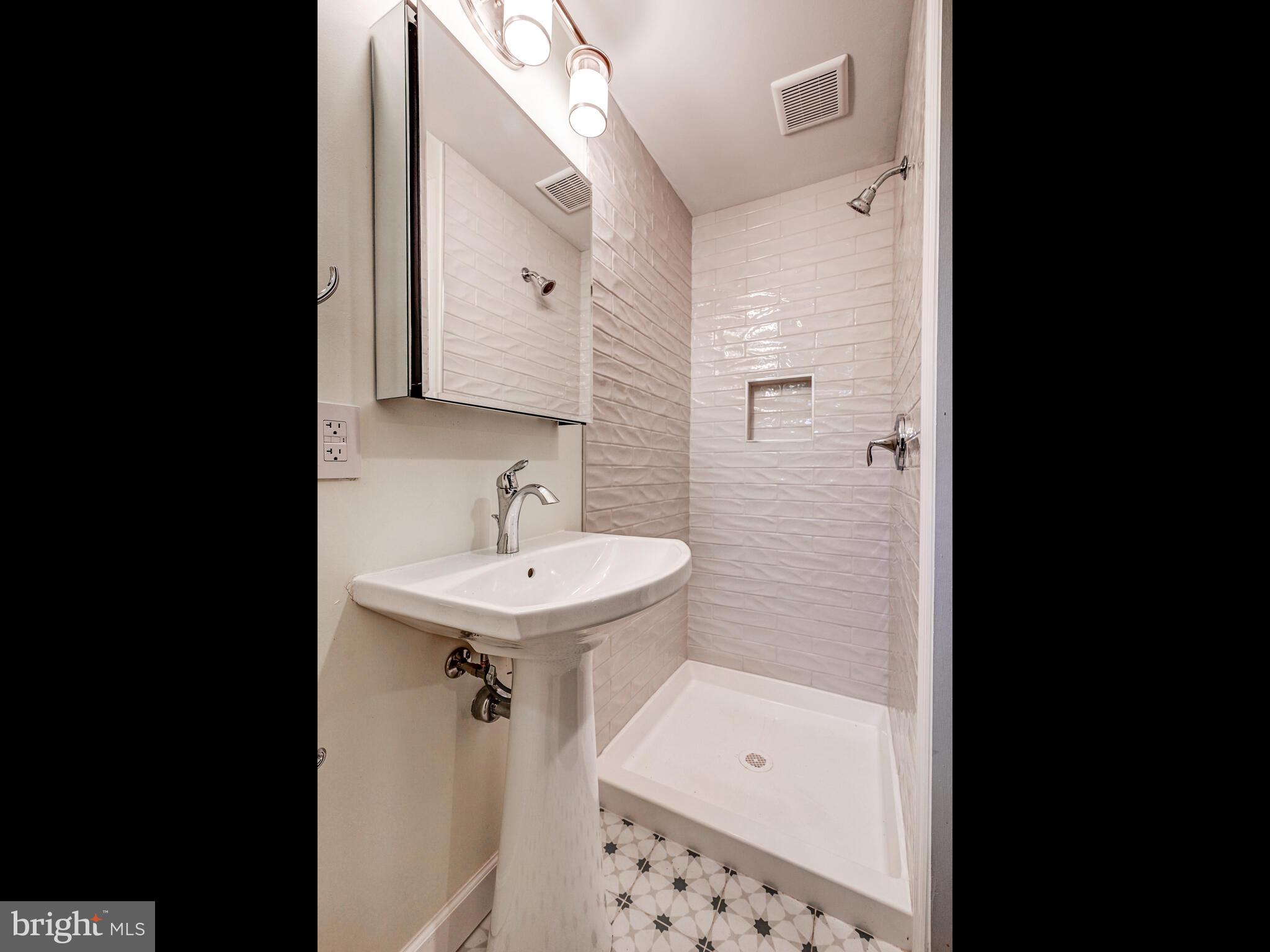 111 Stanmore Road Baltimore, MD 21212 - Photo 27 of 29 a bathroom with a sink a mirror and a bathtub