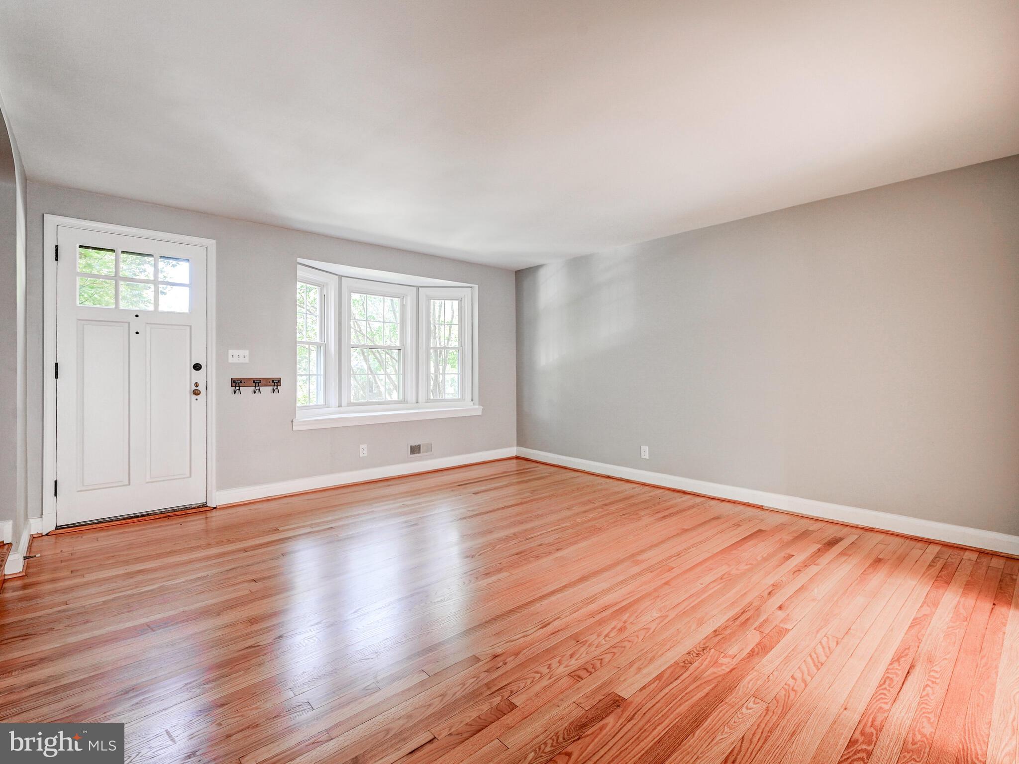 111 Stanmore Road Baltimore, MD 21212 - Photo 6 of 29 an empty room with wooden floor and windows