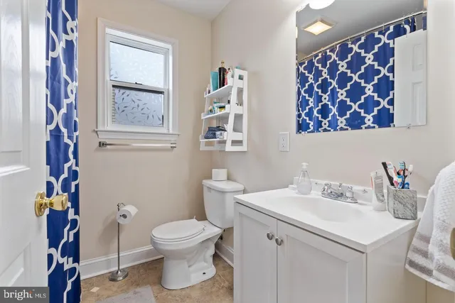 a bathroom with a sink mirror vanity and toilet