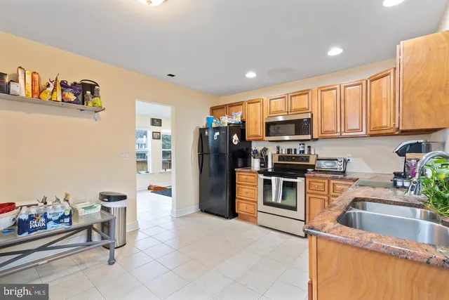 a kitchen with stainless steel appliances granite countertop a refrigerator and a stove top oven