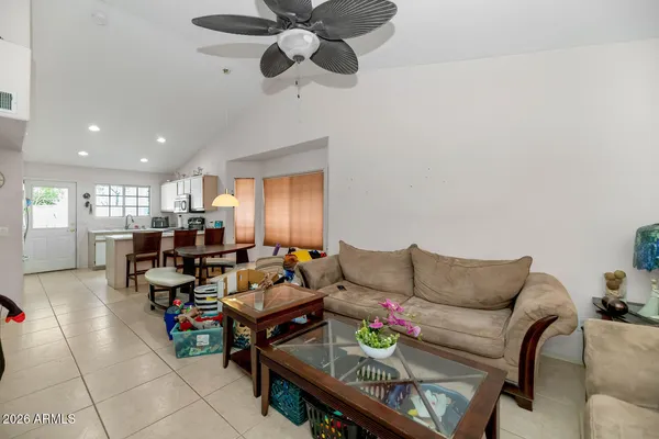 a living room with furniture kitchen view and a chandelier