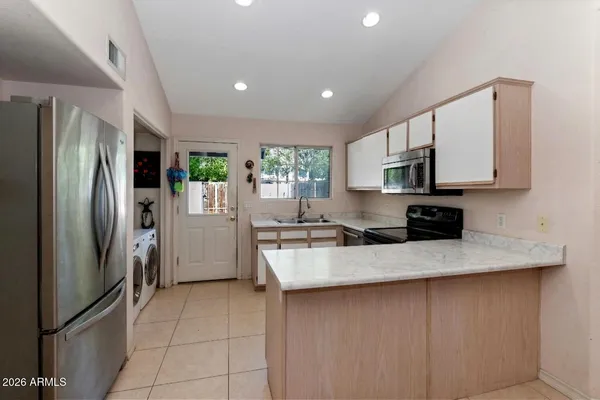 a kitchen with stainless steel appliances granite countertop a refrigerator a stove a sink a microwave and island