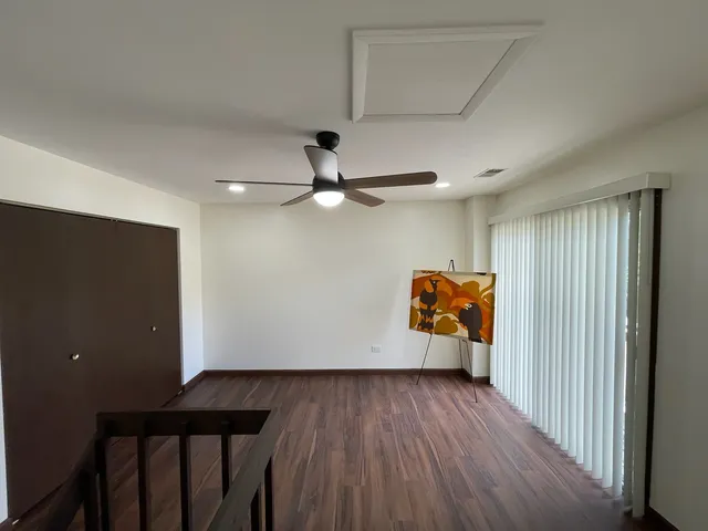 a view of a hallway with wooden floor and stairs
