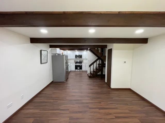 a kitchen with stainless steel appliances a refrigerator a sink and white cabinets