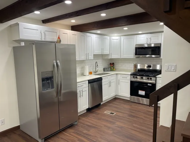 a kitchen with a sink a refrigerator and cabinets