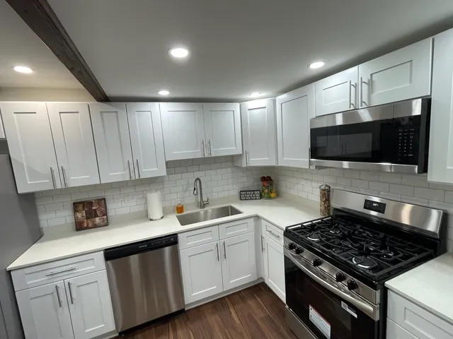 a kitchen with sink a microwave and cabinets