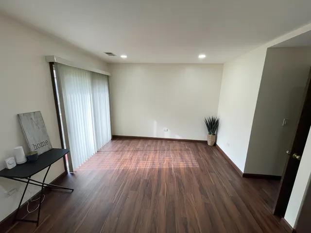 a view of a room with wooden floor and bench