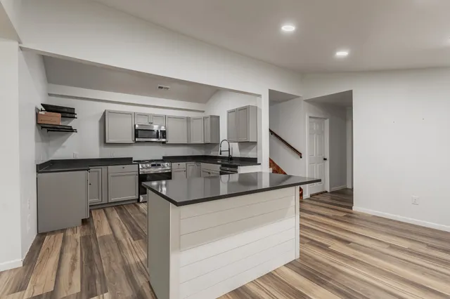 a kitchen with stainless steel appliances granite countertop a stove and a sink