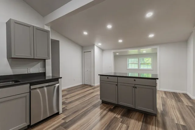 a kitchen with stainless steel appliances granite countertop a stove a sink and a microwave