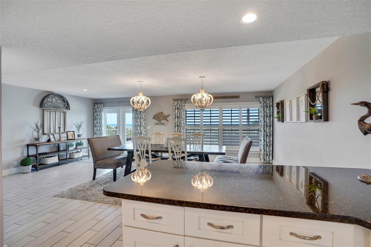 5072 Atlantic View St. Augustine, FL 32080 - Photo 13 of 40 a kitchen with kitchen island granite countertop a sink a stove cabinets and dining table