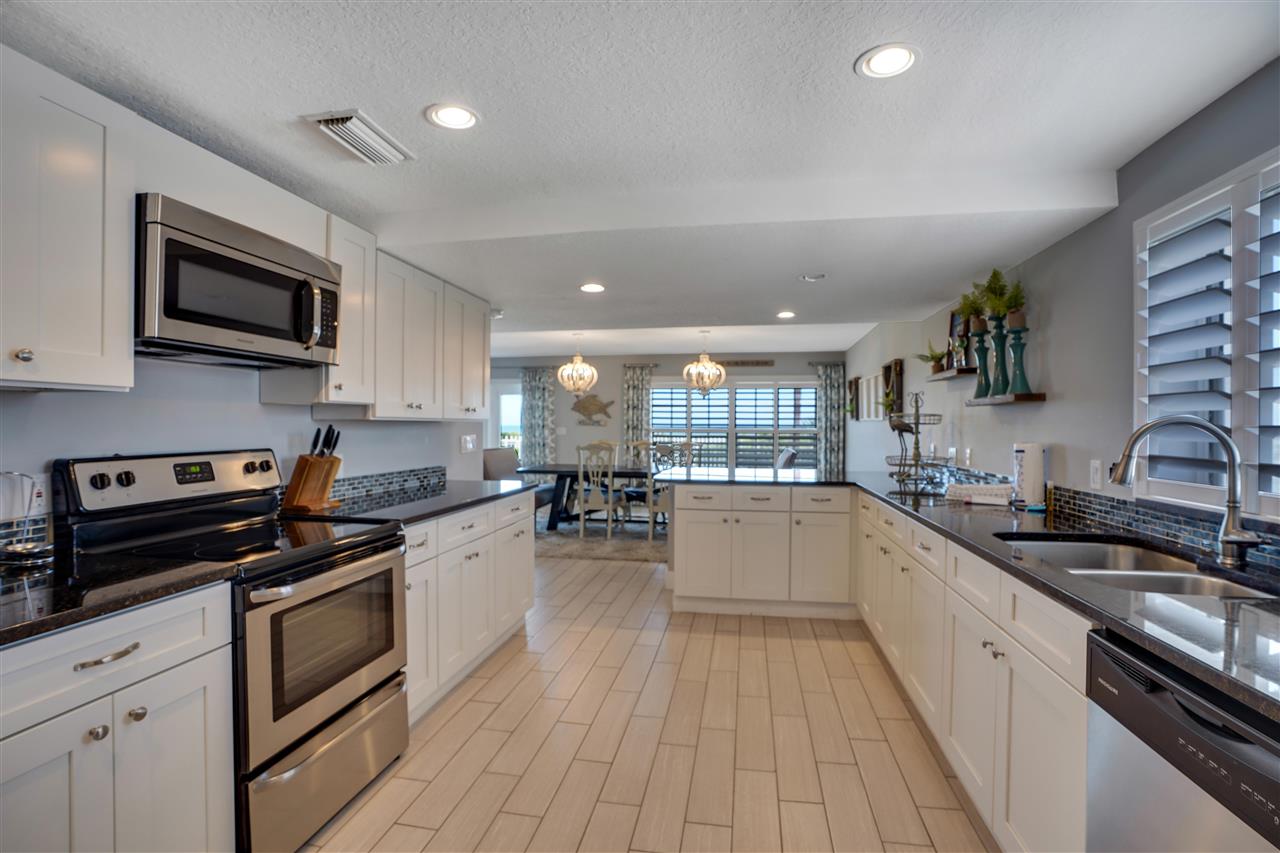 5072 Atlantic View St. Augustine, FL 32080 - Photo 15 of 40 a kitchen with stainless steel appliances a sink dishwasher a stove top oven a refrigerator with wooden floors and cabinets