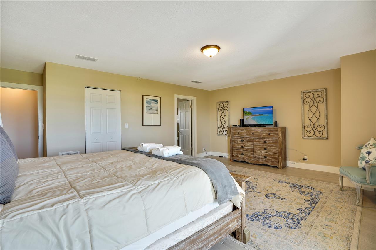 5072 Atlantic View St. Augustine, FL 32080 - Photo 18 of 40 a spacious bedroom with a bed and a lamp on dresser