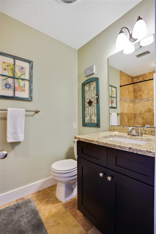 5072 Atlantic View St. Augustine, FL 32080 - Photo 27 of 40 a bathroom with a granite countertop toilet sink and mirror