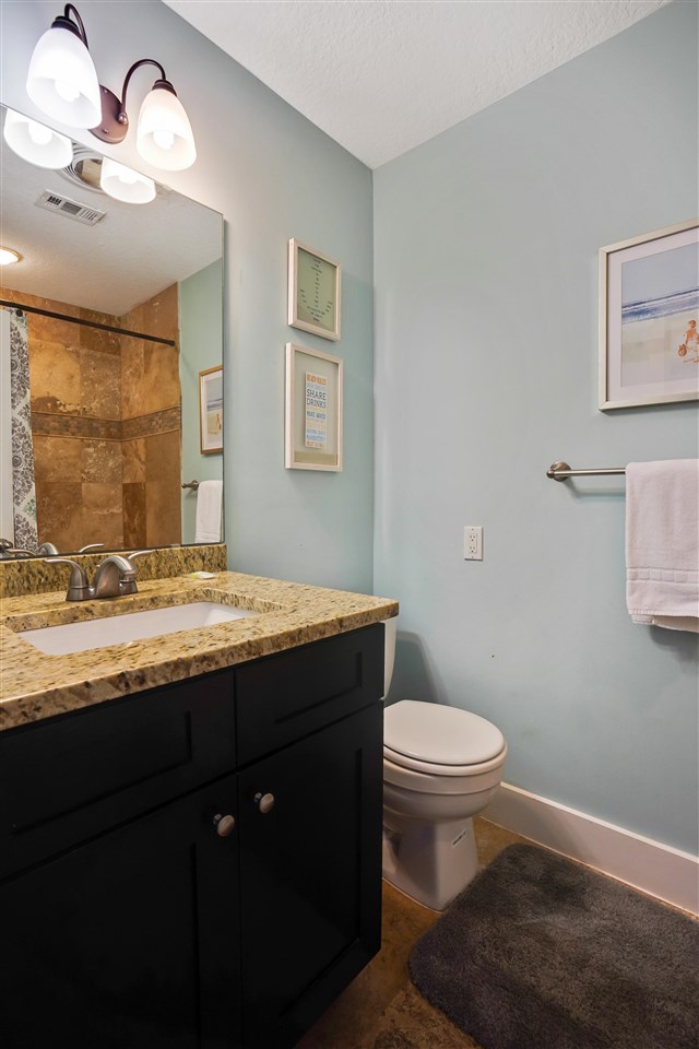 5072 Atlantic View St. Augustine, FL 32080 - Photo 30 of 40 a bathroom with a granite countertop sink a toilet and a window