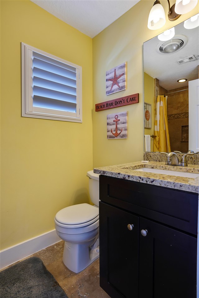 5072 Atlantic View St. Augustine, FL 32080 - Photo 32 of 40 a bathroom with a granite countertop toilet sink and mirror
