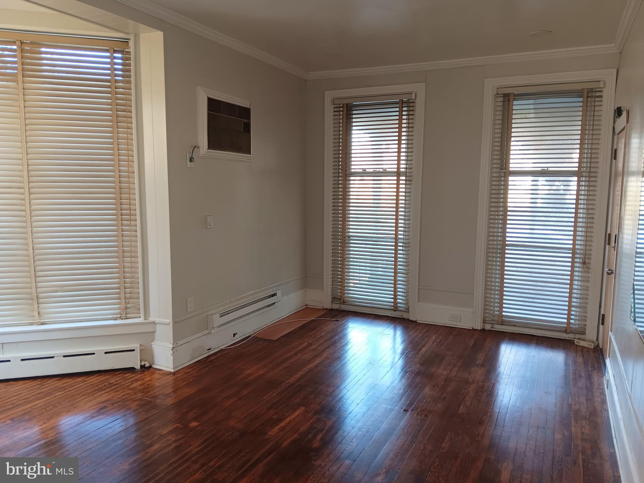 1342 Orthodox Street, Unit 2 Philadelphia, PA 19124 - Photo 2 of 6 an empty room with wooden floor and windows