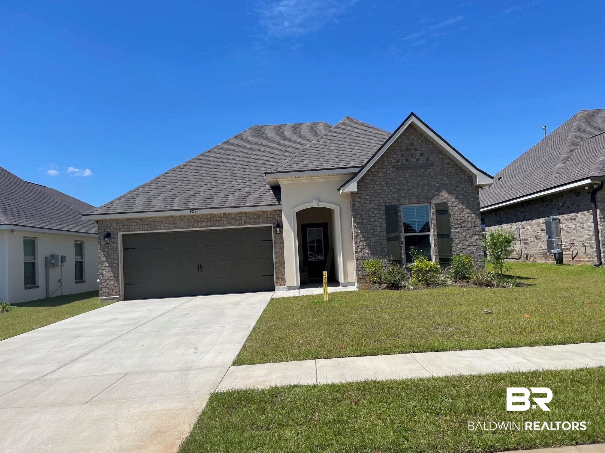 1359 Fenton Circle Foley, AL 36535 - Photo 1 of 3 French provincial home with brick siding, a front lawn, driveway, a garage, and roof with shingles