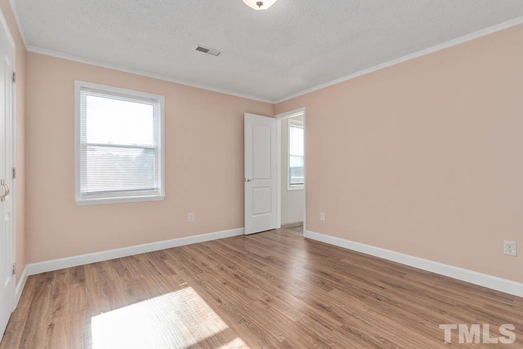 11787 Dunn Road Autryville, NC 28318 - Photo 22 of 30 a view of an empty room with wooden floor and a window