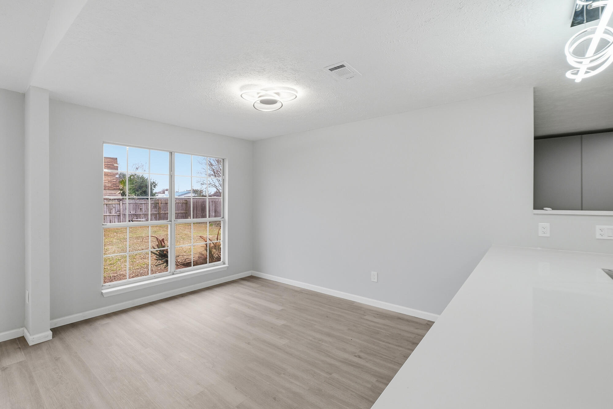 1434 Santa Anita Drive Lynn Haven, FL 32444 - Photo 13 of 38 an empty room with wooden floor and windows