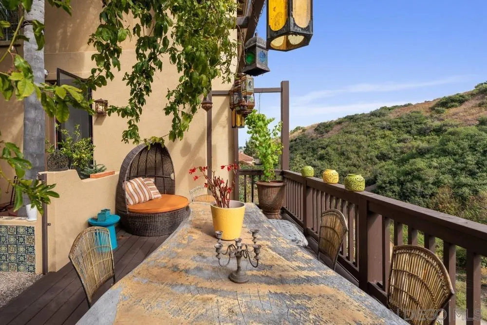 a view of a balcony with chairs and a potted plant