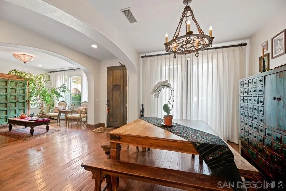 2775 Ridgegate Row La Jolla, CA 92037 - Photo 17 of 59 a bedroom with a bed a chandelier and flat screen tv