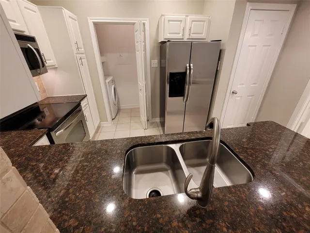 a kitchen with stainless steel appliances granite countertop a sink and a refrigerator