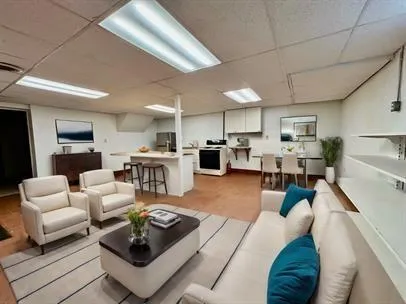 a living room with furniture and a view of kitchen